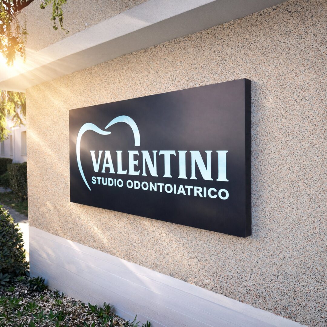 Insegna nera Valentini Studio Odontoiatrico sulla parete esterna