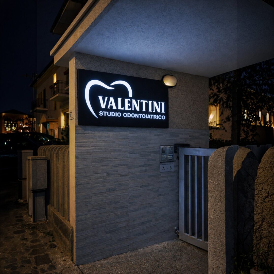 Insegna Valentini Studio Odontoiatrico accesa di sera all'ingresso