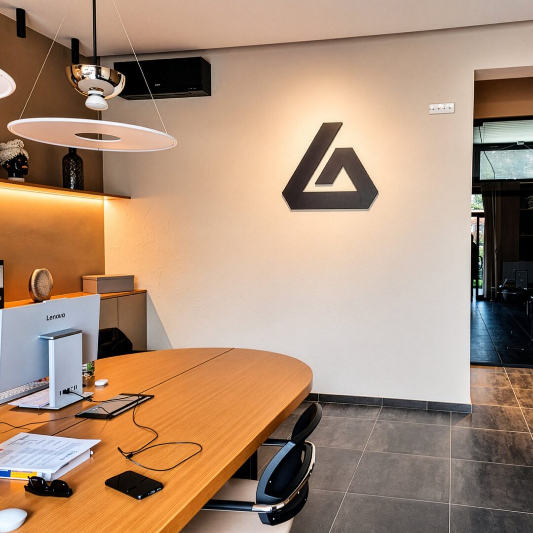 Logo nero a parete in un ufficio con tavolo in legno, di giorno