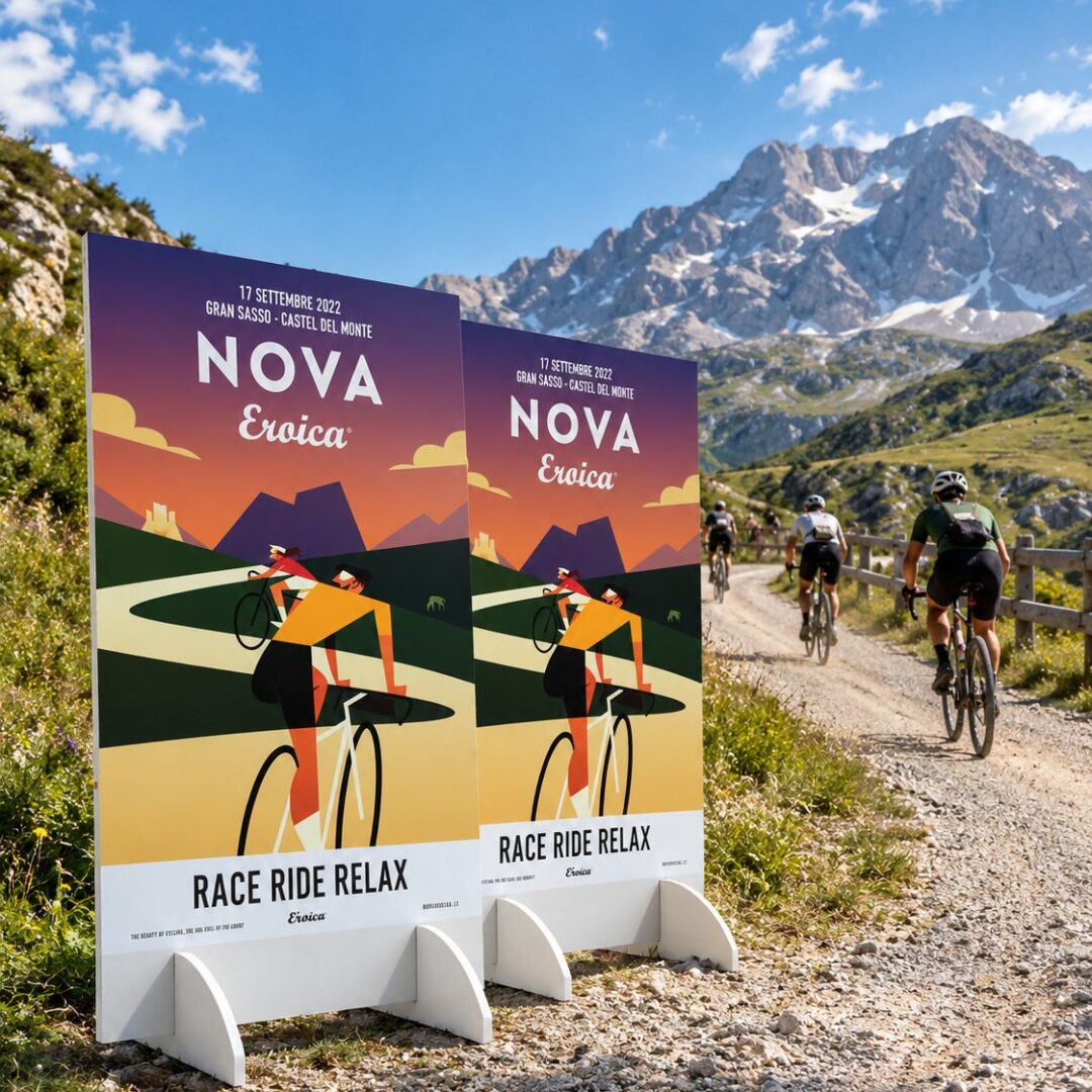 Due totem con la grafica Nova Eroica, inseriti in una foto del Gran Sasso con ciclisti su una strada bianca